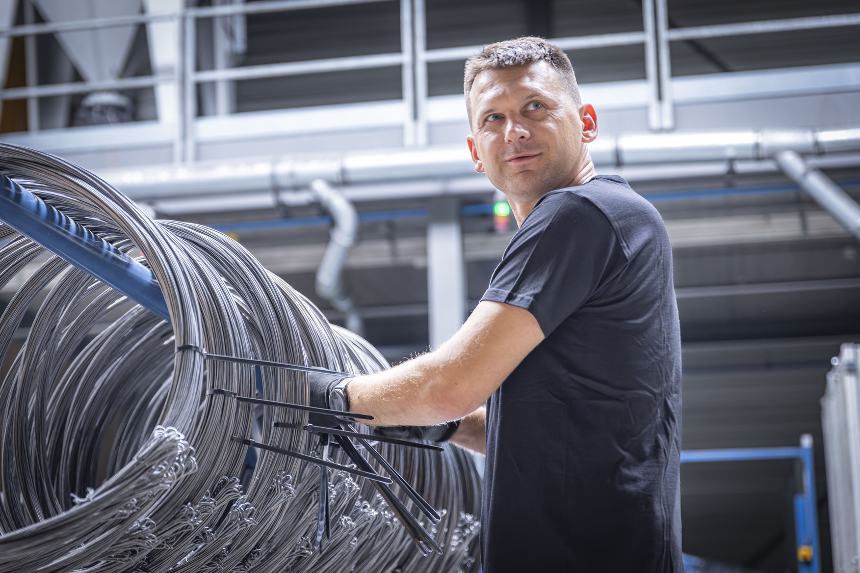 Productiemedewerker controleert quicklinks industriële draad in de fabriek van Metalwire